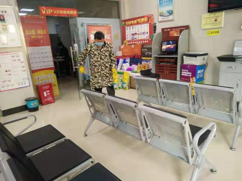 图四为邮政工作人员在对网点消毒处理.png