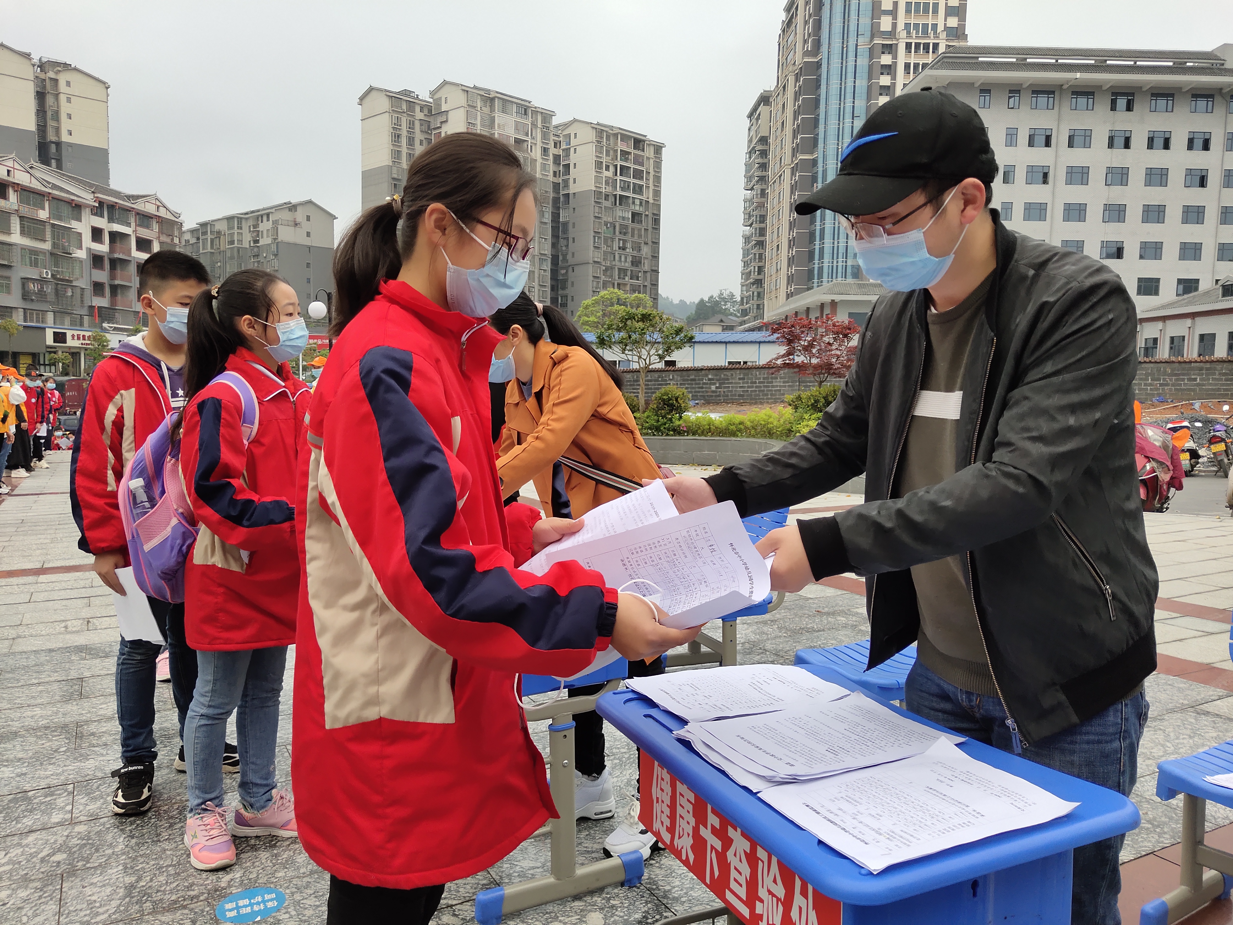一名老师在查验学生健康检测表.jpg