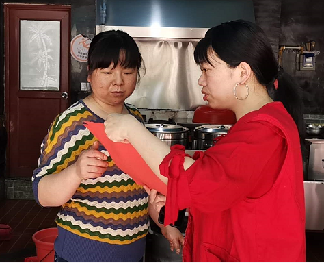图为：科协机关干部给居民讲解“门前三包”内容.png
