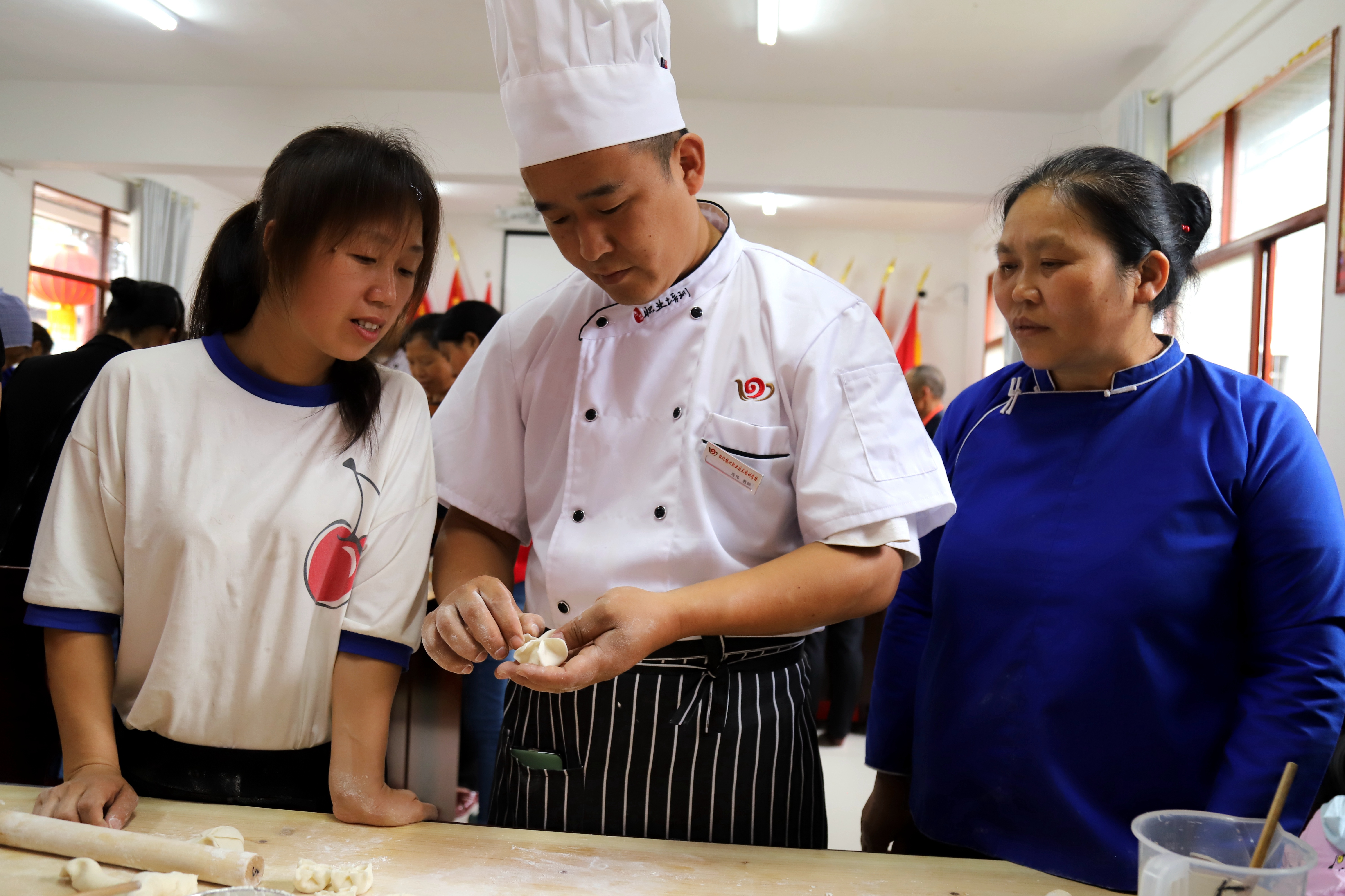 2.厨师为贫困妇女讲述饺子制作技巧。.jpg