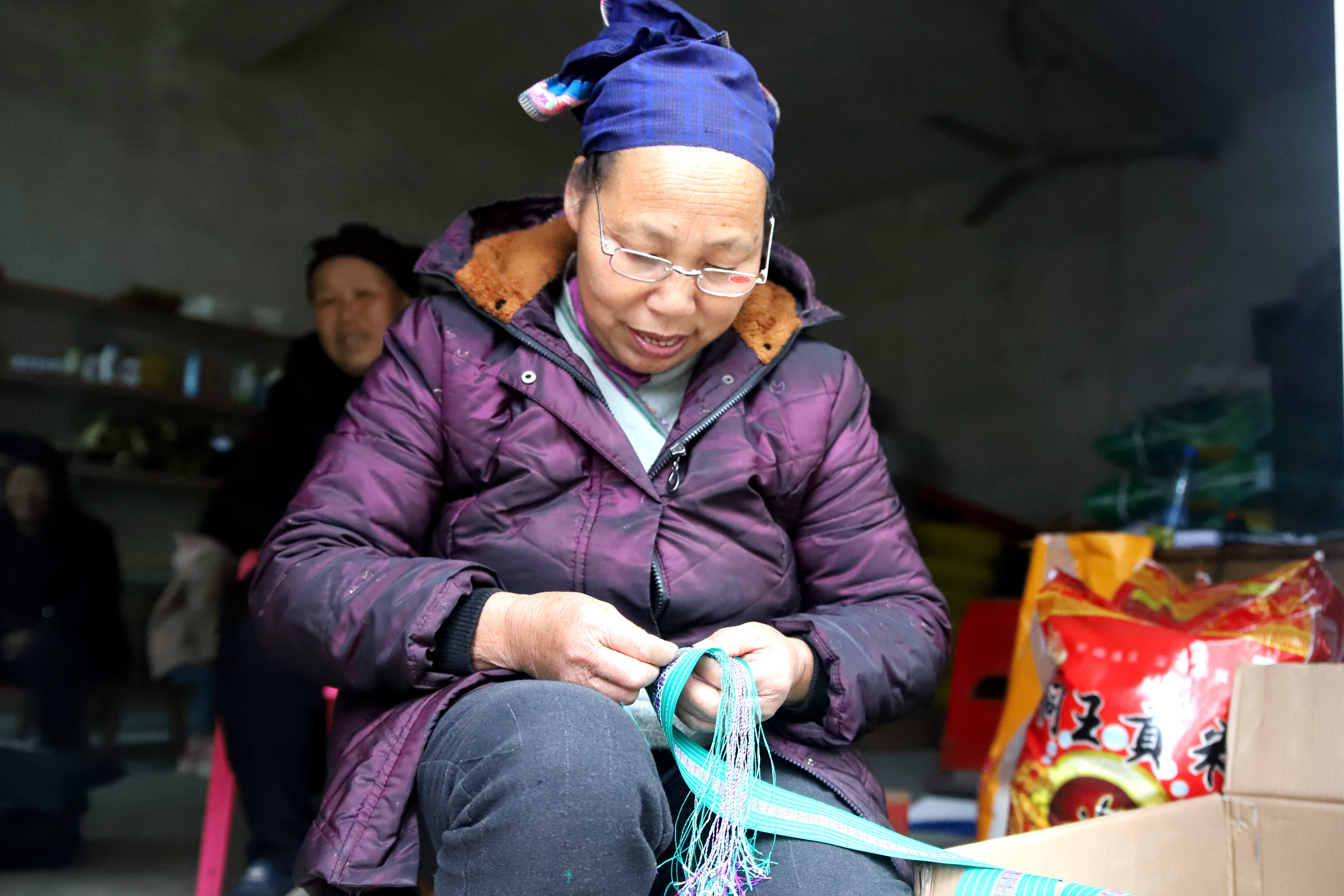 2.苗族妇女在编织当地传统腰带。.jpg