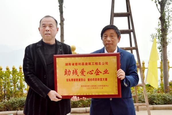 “慈爱之家”负责人王开慈（右）为公司赠与爱心牌匾示谢意(1).jpg